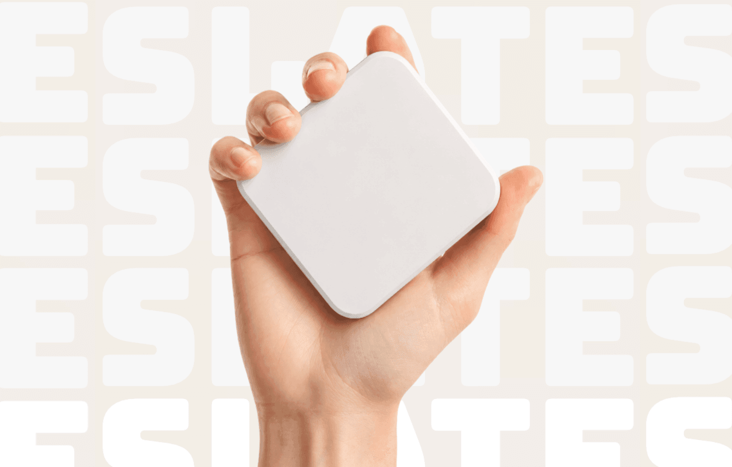 A hand holding a white Slate block against a Slate-patterned background