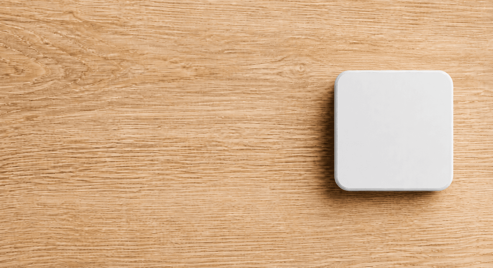 A white Slate Block resting on a wood surface