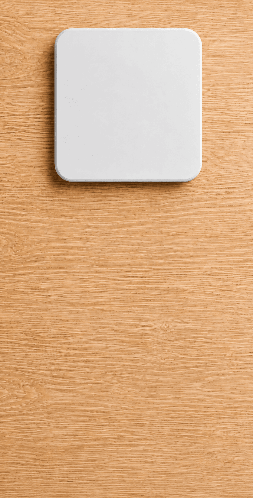 A white Slate Block resting on a wood surface
