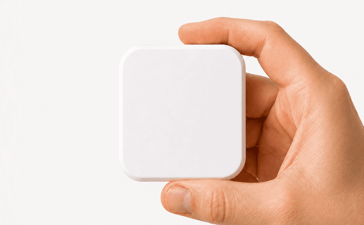 A hand holding a single white Slate block